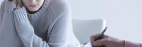 Woman pauses during talk therapy session.